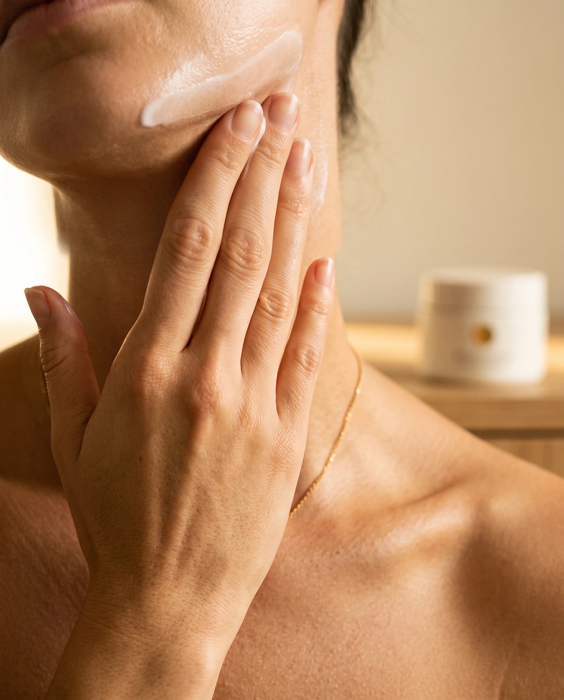 Hand smoothing cream on jaw