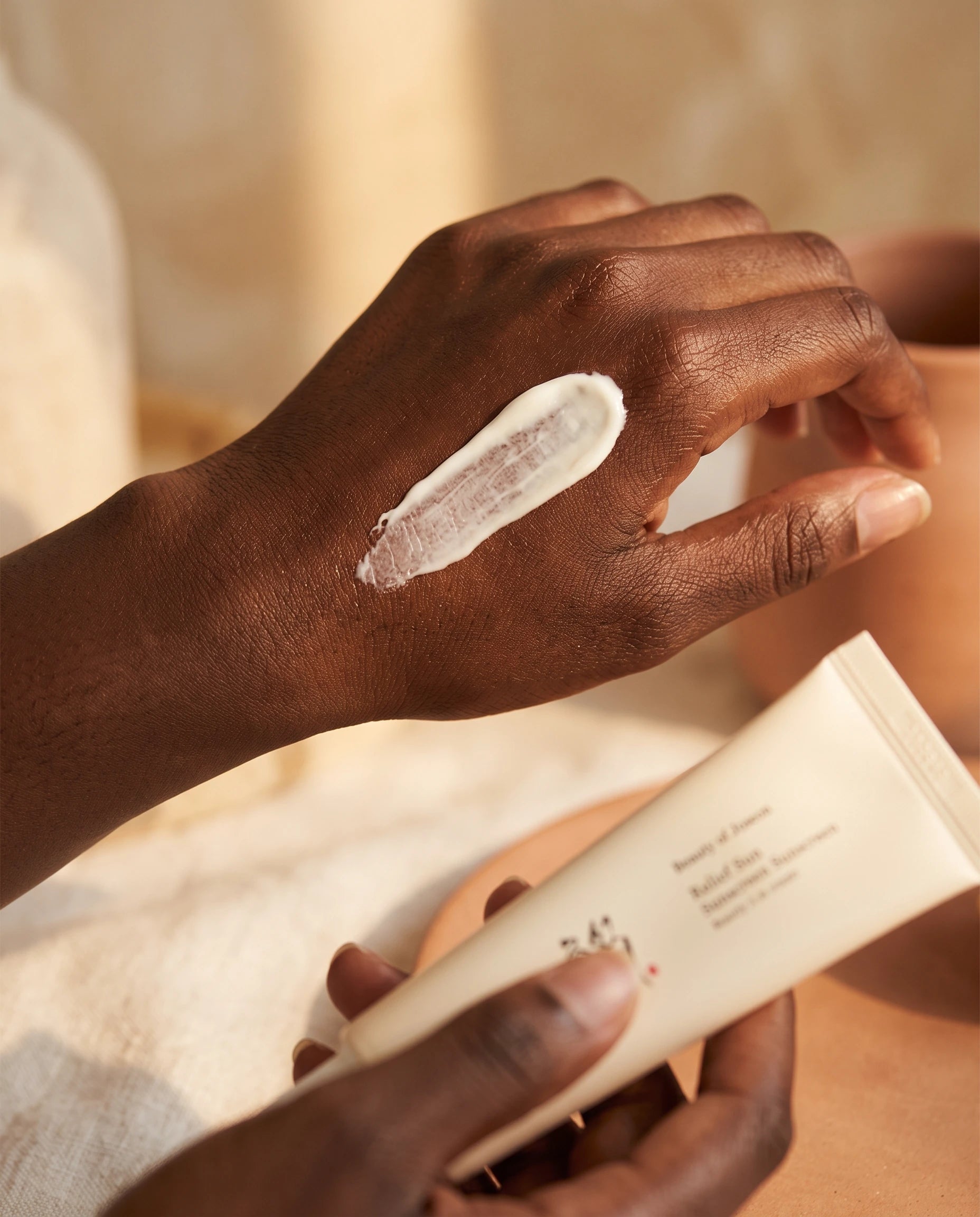 Fingertips blending SPF into skin